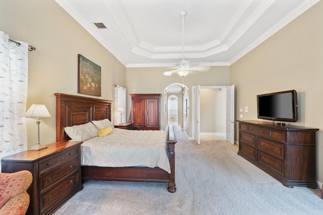 bedroom featuring arched walkways, a raised ceiling, light colored carpet, visible vents, and ornamental molding