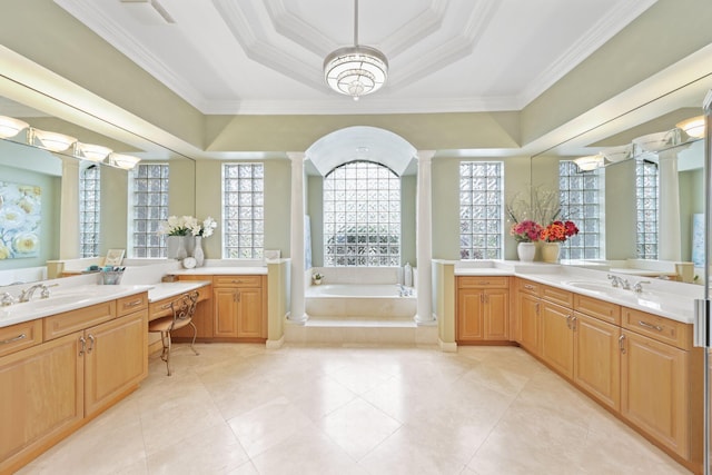 full bathroom featuring a garden tub, a sink, ornamental molding, a tray ceiling, and decorative columns