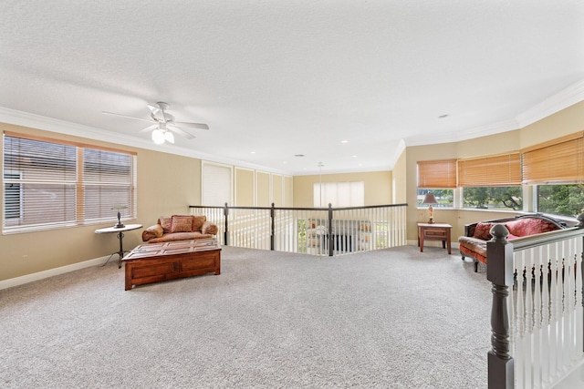 sitting room with ornamental molding, carpet flooring, a textured ceiling, and baseboards