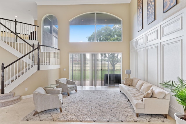 living area with baseboards, light tile patterned floors, stairway, and a healthy amount of sunlight