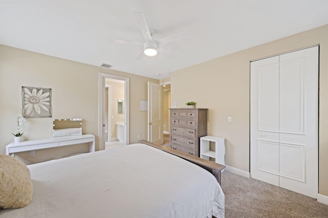 carpeted bedroom with a closet, visible vents, a ceiling fan, ensuite bath, and baseboards