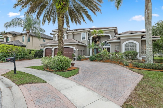 view of front of house with a tiled roof, decorative driveway, and stucco siding