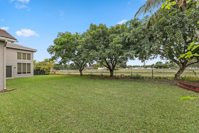 view of yard featuring a rural view and fence