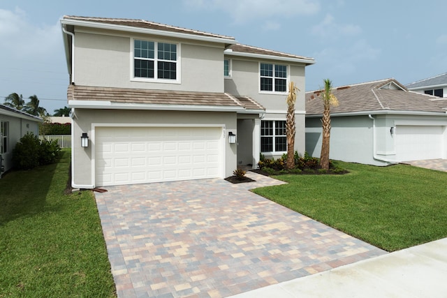 view of front of home featuring a front lawn, decorative driveway, and stucco siding