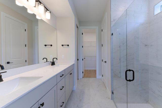 bathroom with a stall shower, marble finish floor, a sink, and a spacious closet