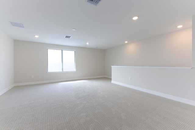 empty room featuring light colored carpet, visible vents, and recessed lighting