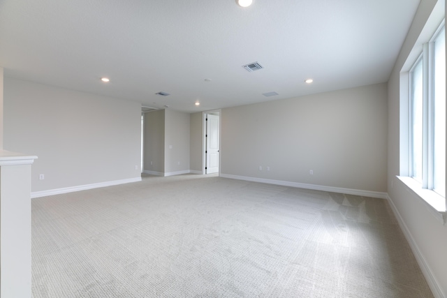 empty room featuring baseboards, light colored carpet, visible vents, and recessed lighting