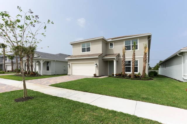 view of front of house featuring an attached garage, a front lawn, decorative driveway, and stucco siding