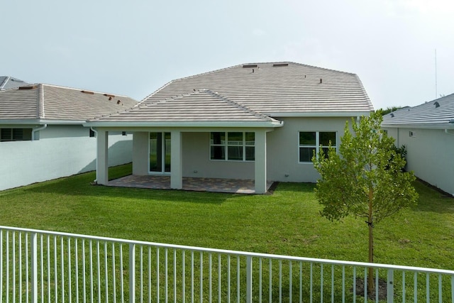 rear view of property with fence private yard, stucco siding, a patio, and a tiled roof