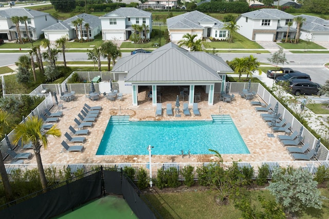 community pool featuring a fenced backyard, a residential view, and a patio