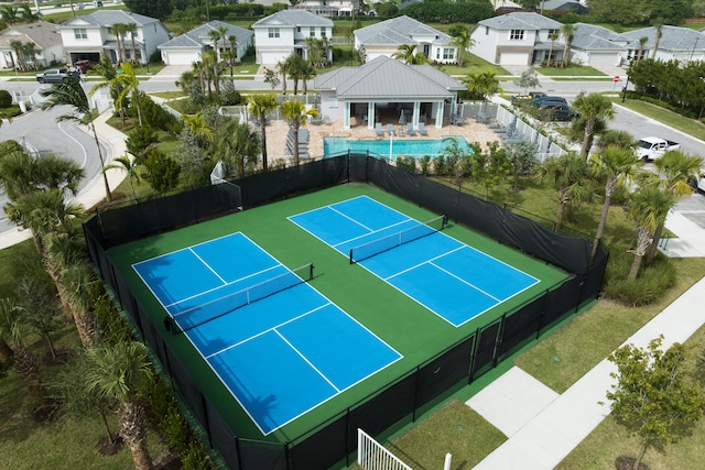 view of sport court with fence and a residential view