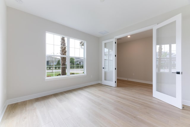 unfurnished room featuring light wood-style floors, french doors, and baseboards