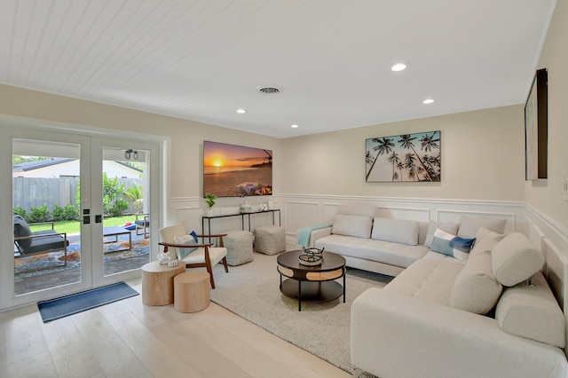 living room with a wainscoted wall, french doors, wood finished floors, and recessed lighting