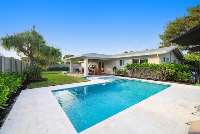 view of swimming pool with a patio area, a fenced backyard, a fenced in pool, and a yard