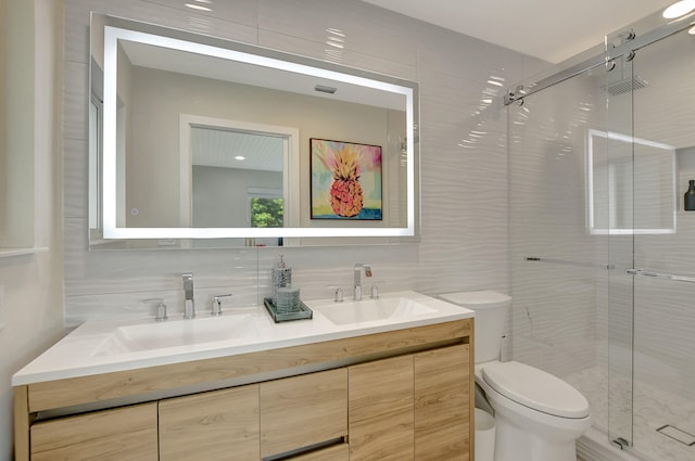 bathroom with double vanity, a sink, toilet, and a shower stall