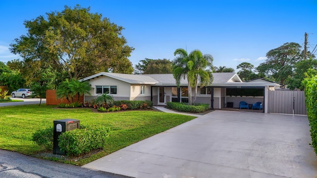 ranch-style house featuring a garage, fence, driveway, stucco siding, and a front lawn