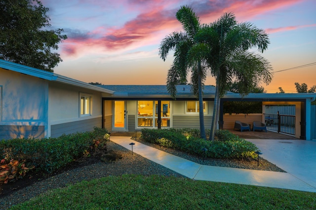 view of front of home featuring concrete driveway, an attached carport, and stucco siding