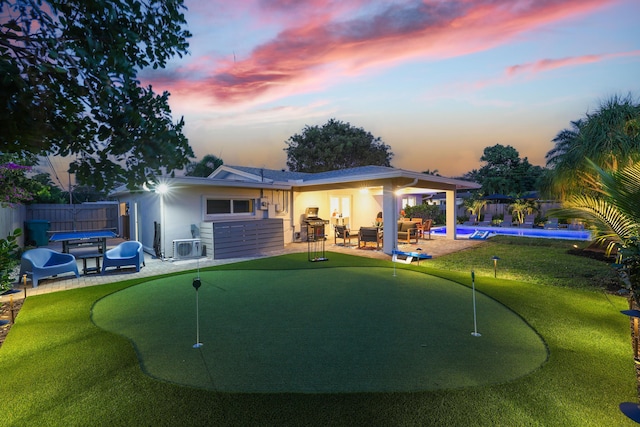 rear view of property featuring a patio, fence, and a fenced in pool