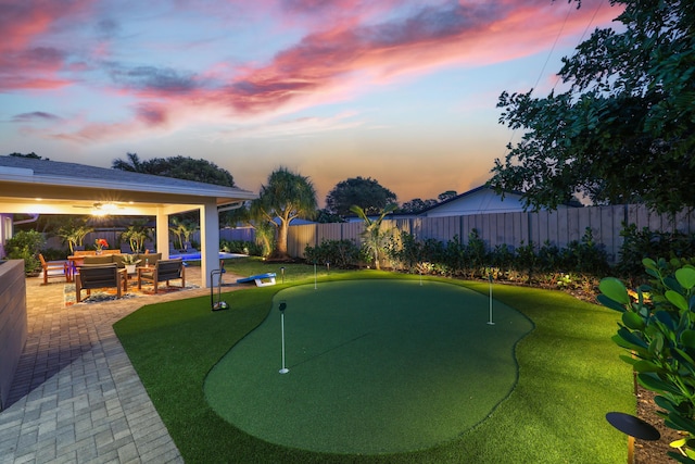 yard at dusk with a fenced backyard and a patio