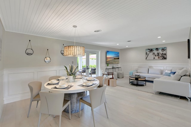 dining room featuring visible vents, french doors, light wood-type flooring, a decorative wall, and recessed lighting