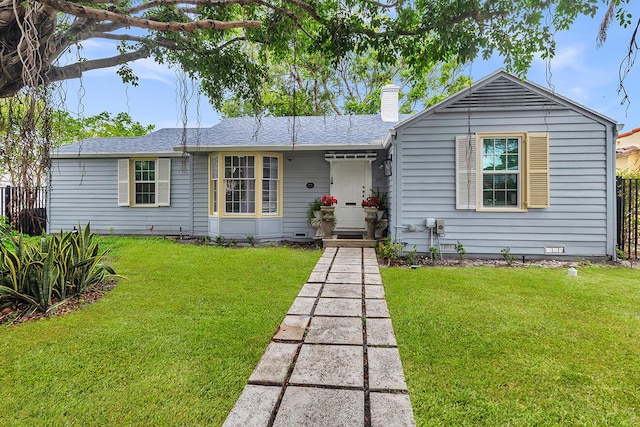 ranch-style home featuring a shingled roof, fence, a chimney, and a front lawn