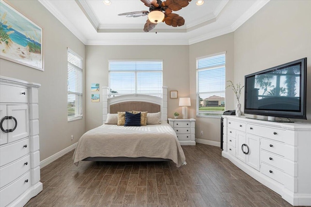 bedroom with dark wood-style floors, baseboards, a tray ceiling, and crown molding