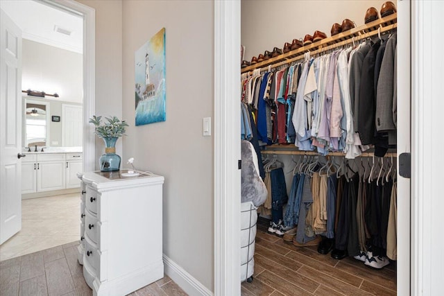 spacious closet featuring wood finish floors and visible vents