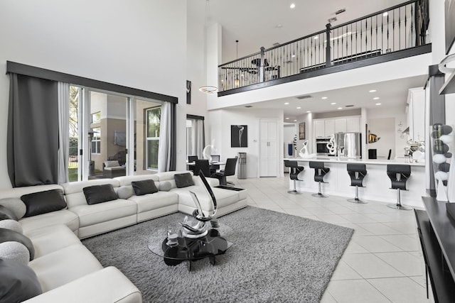 living area featuring light tile patterned floors, a towering ceiling, and recessed lighting