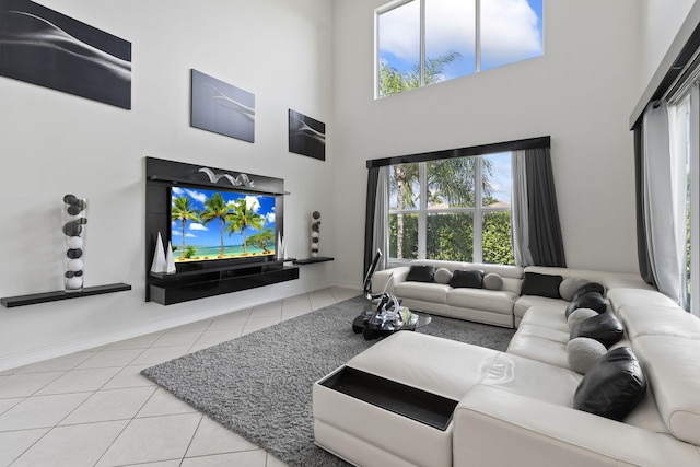 tiled living room with a towering ceiling and baseboards