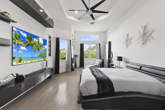 bedroom featuring recessed lighting, a raised ceiling, visible vents, a ceiling fan, and wood finished floors