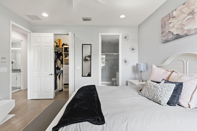 bedroom featuring recessed lighting, a closet, visible vents, a spacious closet, and wood finished floors