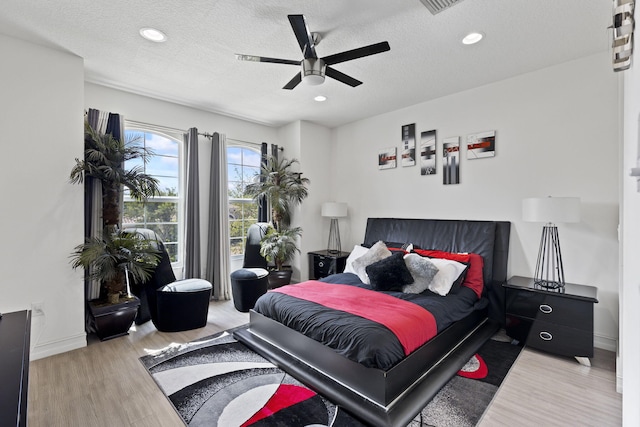 bedroom featuring recessed lighting, a ceiling fan, a textured ceiling, wood finished floors, and baseboards