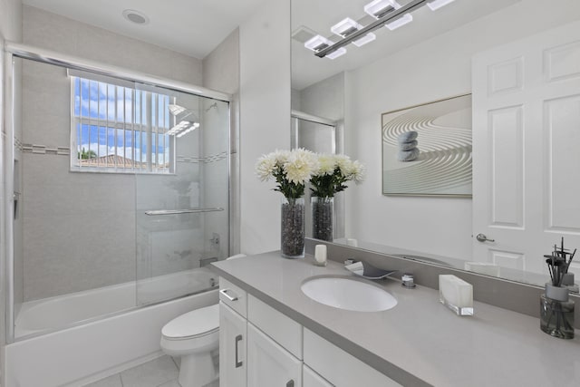 full bathroom with enclosed tub / shower combo, vanity, toilet, and tile patterned floors