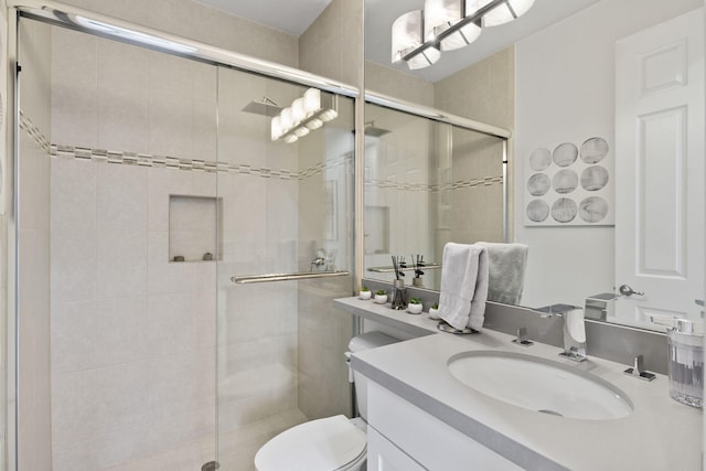 bathroom with a stall shower, vanity, and toilet