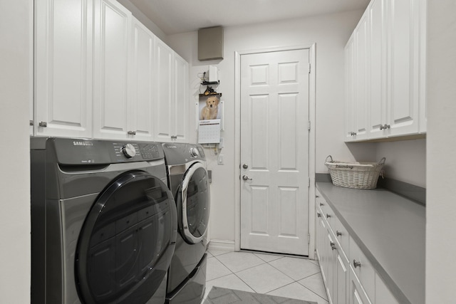 laundry area featuring cabinet space, washer and clothes dryer, and light tile patterned floors