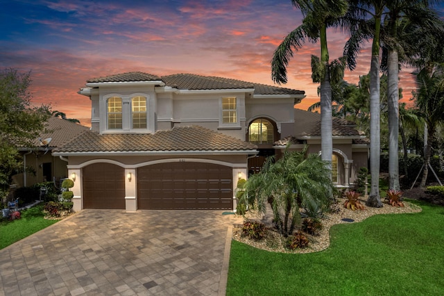 mediterranean / spanish home featuring a tiled roof and stucco siding