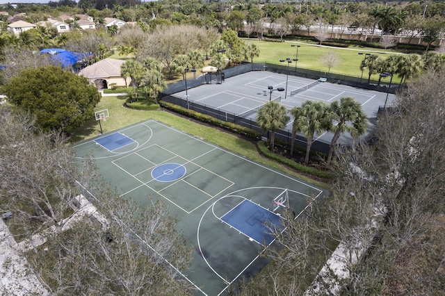 view of sport court with a tennis court, community basketball court, a yard, and fence