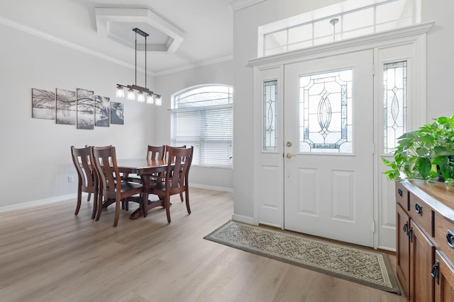 entrance foyer with baseboards, light wood-style floors, and crown molding