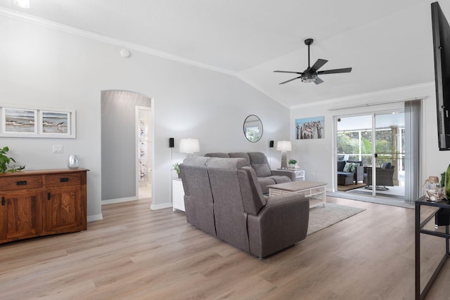 living area featuring arched walkways, lofted ceiling, light wood-style flooring, ornamental molding, and baseboards