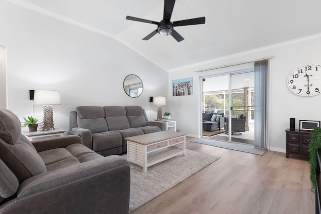 living room with lofted ceiling, ornamental molding, ceiling fan, light wood-type flooring, and baseboards