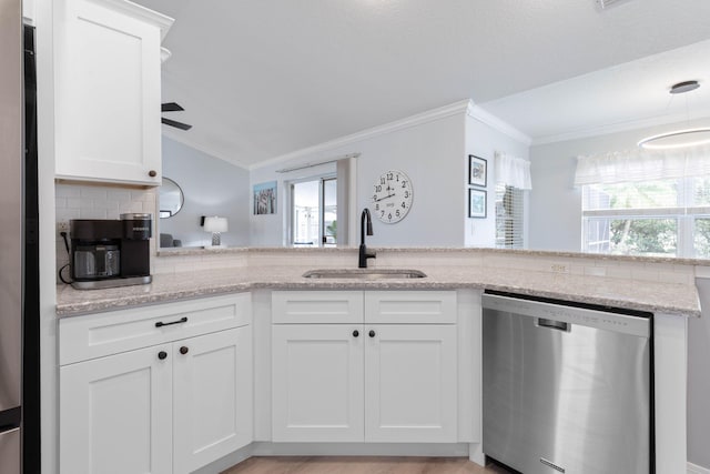 kitchen featuring white cabinets, a sink, light stone countertops, dishwasher, and a peninsula