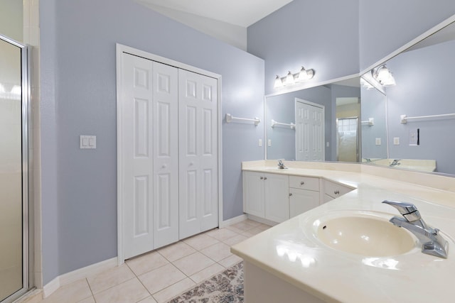 full bath with a closet, double vanity, a sink, and tile patterned floors