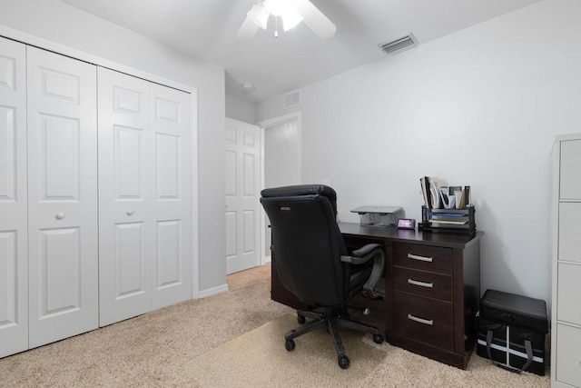 office space featuring light colored carpet, visible vents, and ceiling fan