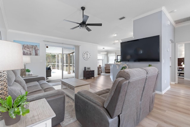 living area featuring ornamental molding, light wood-type flooring, a wealth of natural light, and visible vents