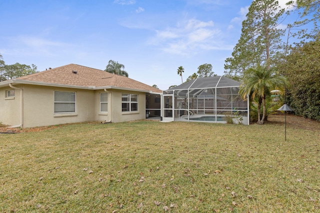 rear view of house with a lanai, an outdoor pool, a lawn, and stucco siding