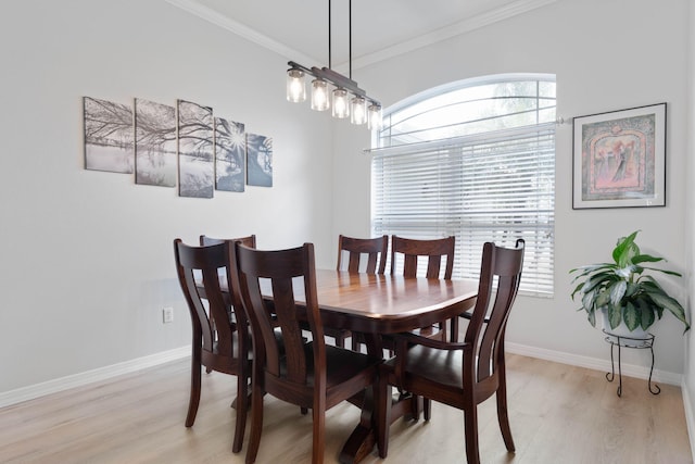 dining area featuring ornamental molding, light wood-style floors, and baseboards