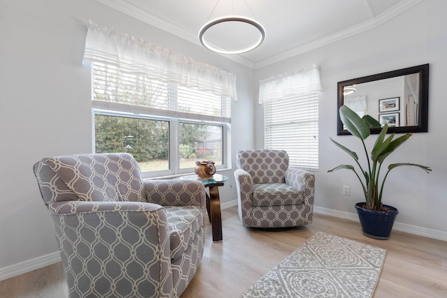 sitting room featuring ornamental molding, light wood-type flooring, and baseboards