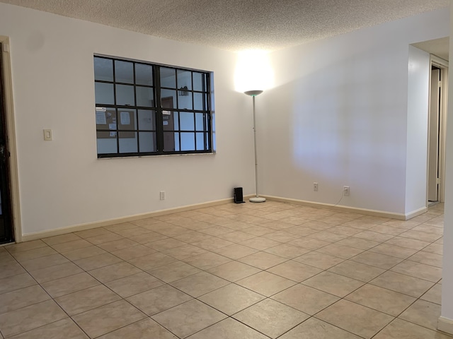 unfurnished room featuring baseboards and a textured ceiling