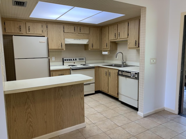 kitchen featuring under cabinet range hood, white appliances, a sink, light countertops, and decorative backsplash