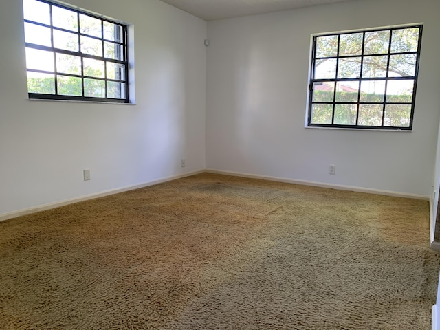 carpeted spare room with baseboards